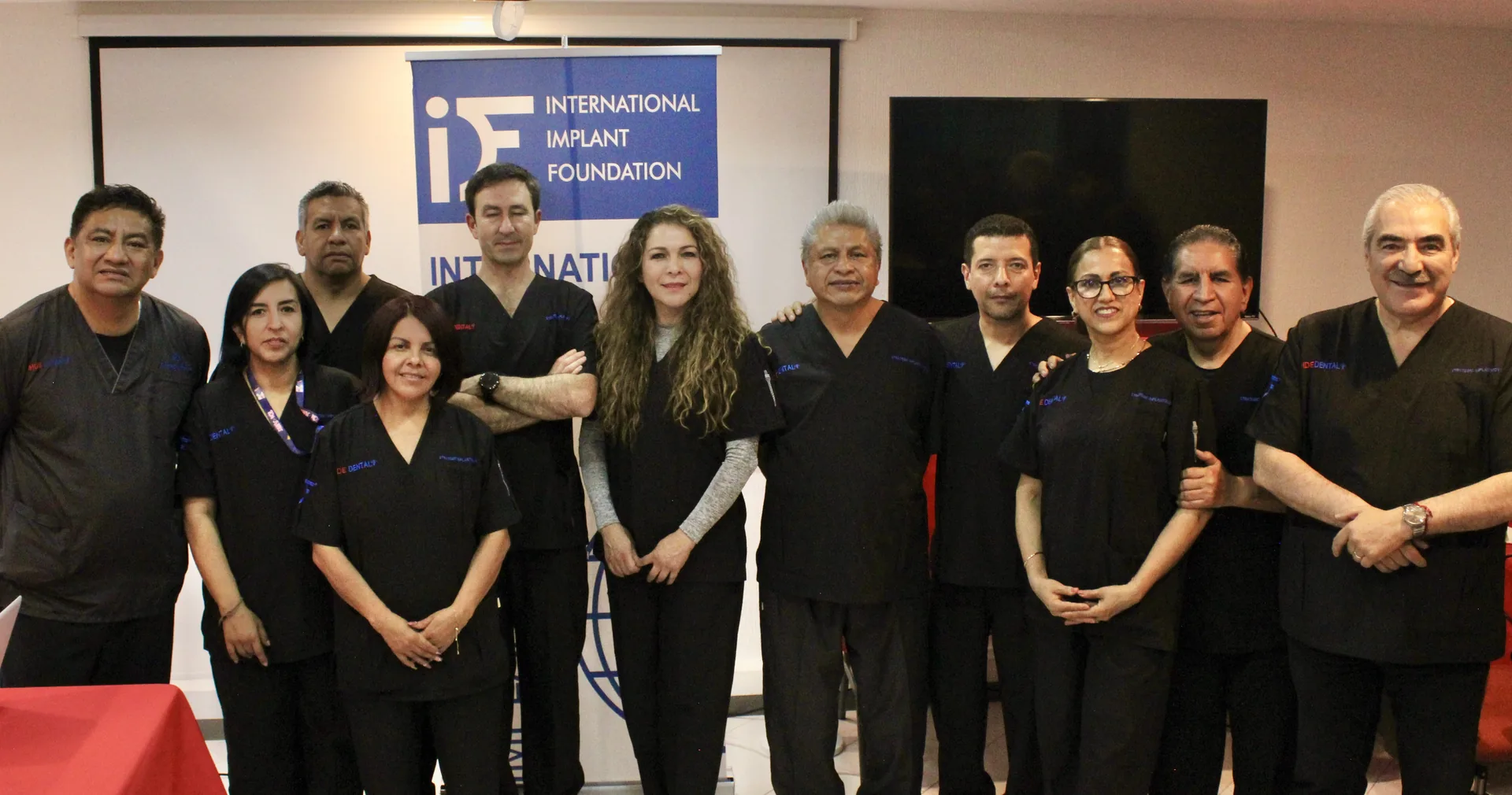 Cohorte del diplomado junto al cartel de la International Implant Foundation